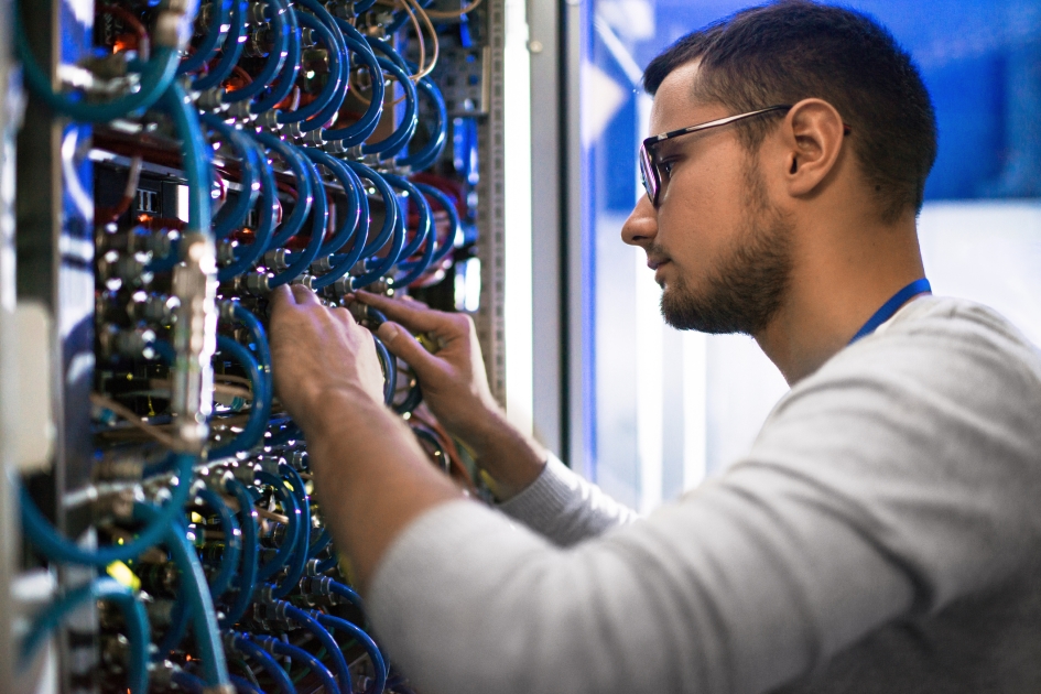 An information technology worker rewiring computer server.